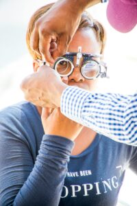 Person reading small print while comparing clear and blurry text through eyeglass lenses.